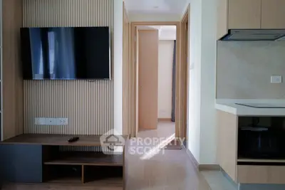 Modern apartment interior with wall-mounted TV and sleek kitchen design