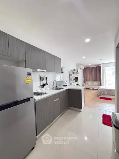 Modern open-layout kitchen with sleek cabinetry and adjacent cozy living area