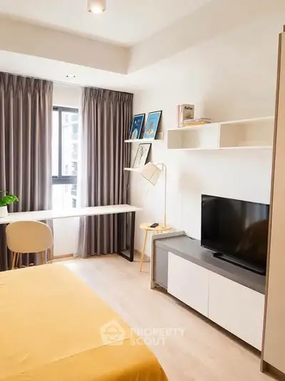 Modern bedroom with study area, featuring a sleek desk, TV, and stylish decor.