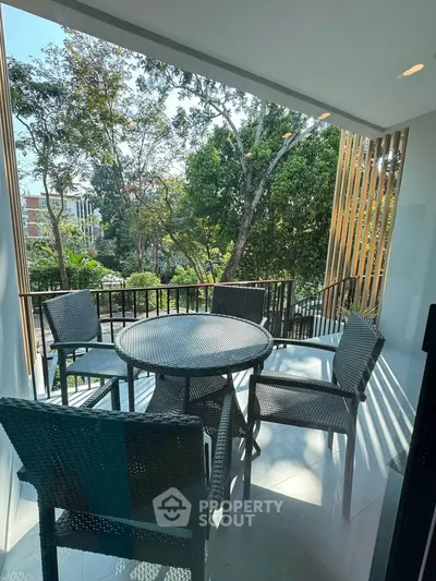 Charming balcony with outdoor seating and lush garden view, perfect for relaxation and entertaining.