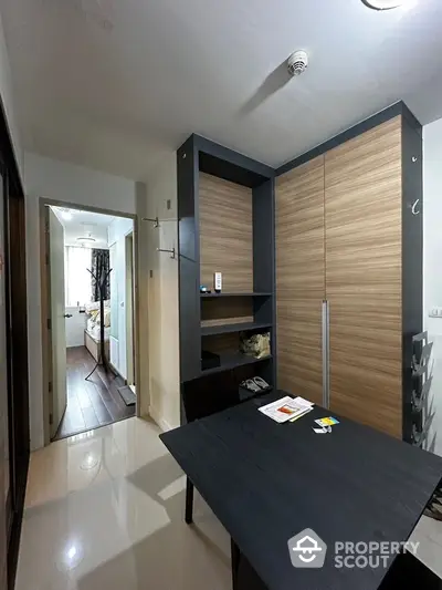 Modern apartment interior with sleek dining area and spacious bedroom view.