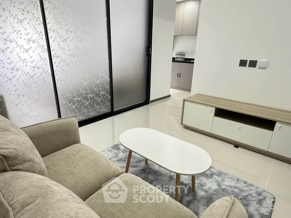Modern living room with cozy beige sofa and sleek white coffee table on plush rug.