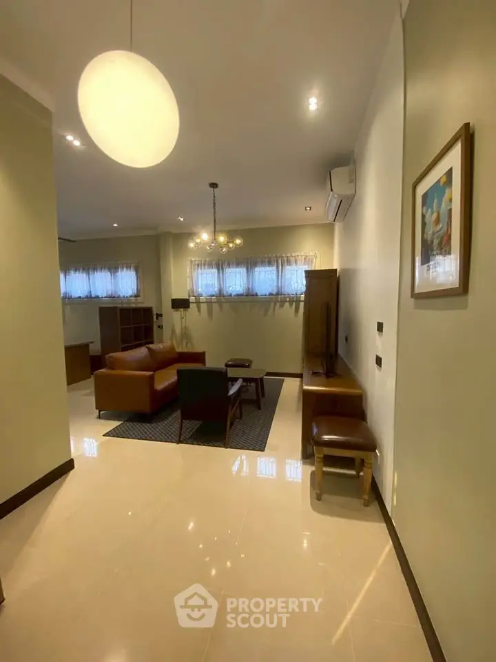 Spacious living room with modern furniture and elegant lighting in a stylish apartment.