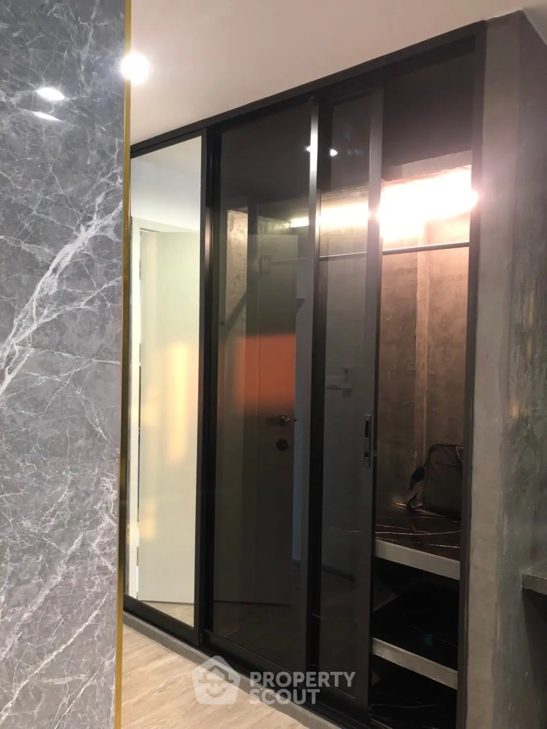 Modern interior with sleek glass sliding doors and marble wall accent