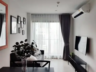 Modern living room with stylish decor, large window, and air conditioning unit.