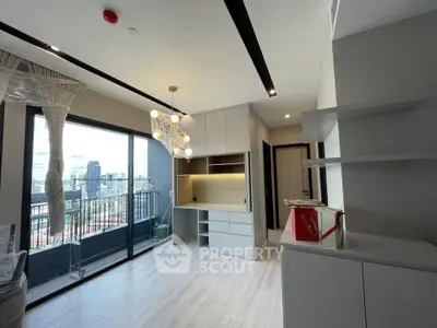 Modern living room with balcony and city view, featuring sleek cabinetry and contemporary lighting.