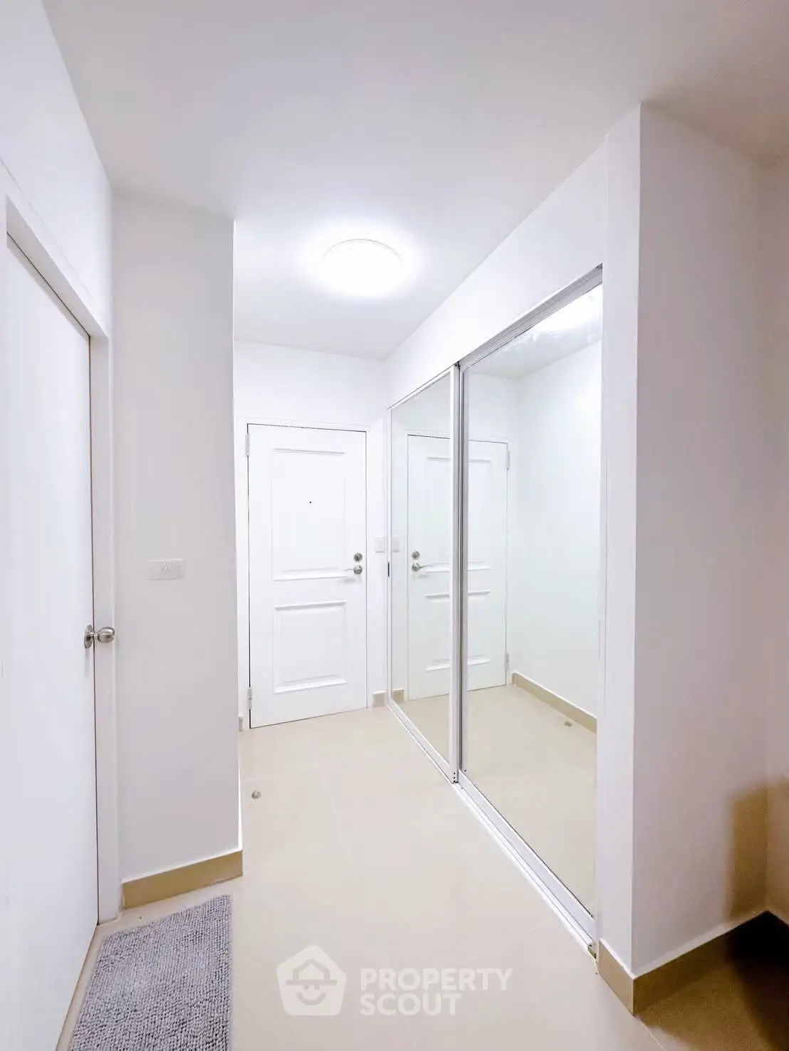 Bright and modern hallway with mirrored closet doors in a contemporary apartment.