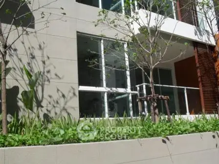 Modern building exterior with lush greenery and large windows