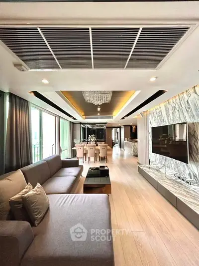 Luxurious open living room with elegant decor and spacious layout, featuring a modern kitchen and dining area.