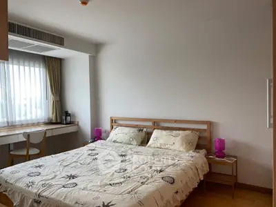 Spacious bedroom with natural light and modern furnishings in a cozy apartment.
