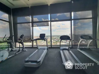 Modern gym with panoramic city view and state-of-the-art equipment.