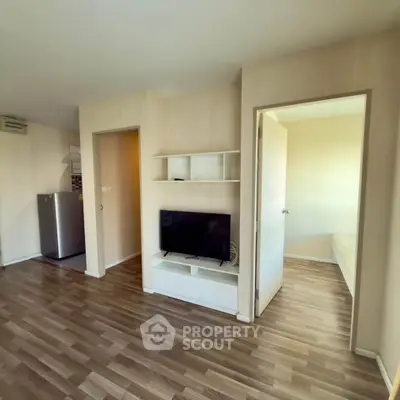 Modern apartment interior with open layout, featuring a cozy living area and visible bedroom.