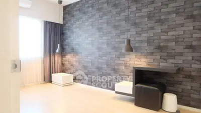 Modern minimalist living room with brick accent wall and pendant lighting