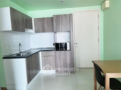 Modern kitchen with sleek cabinetry and dining area in a stylish apartment.