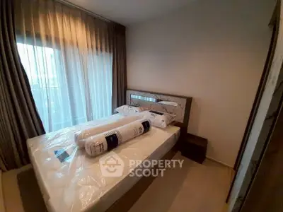 Cozy bedroom with new bedding and large window for natural light