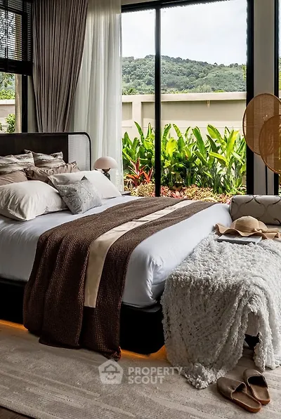 Luxurious bedroom with large windows offering stunning garden views, elegant decor, and cozy bedding.