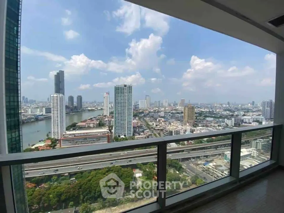 Stunning cityscape view from high-rise balcony overlooking river and skyline.