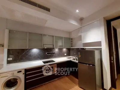 Modern kitchen with sleek appliances and stylish cabinetry in a contemporary apartment.