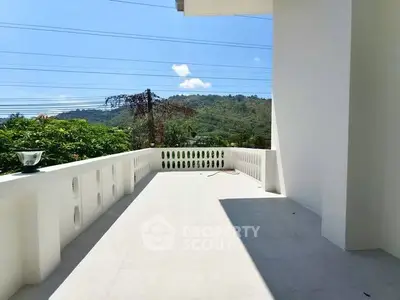 Spacious balcony with scenic mountain view and modern white railing, perfect for relaxation.