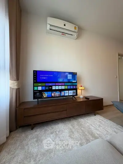 Modern living room with sleek TV setup and air conditioning, perfect for relaxation and entertainment.