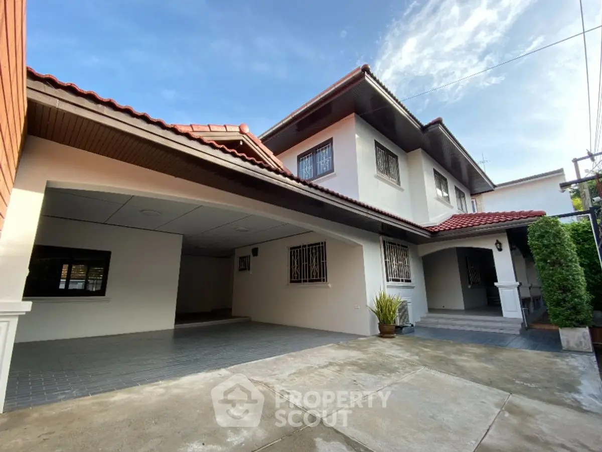 Spacious two-story house with garage and red-tiled roof in a serene neighborhood.