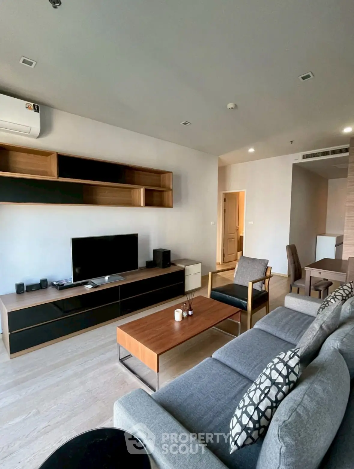 Spacious modern living room with stylish furniture and entertainment center, perfect for relaxation and gatherings.