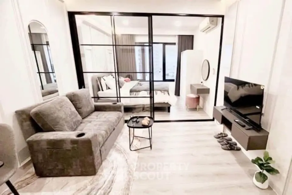 Modern living room with glass partition, cozy sofa, and stylish decor in a contemporary apartment.