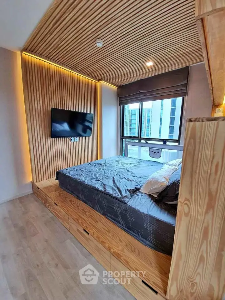 Modern bedroom with wooden accents and large window in urban apartment