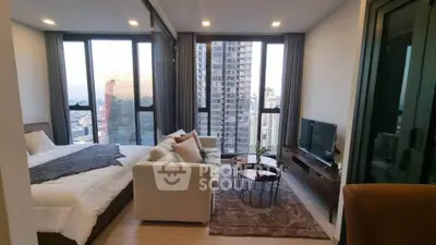 Luxurious modern bedroom with stunning city view and cozy seating area.