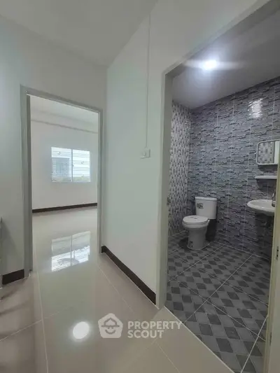 Modern apartment interior with tiled bathroom and bright hallway
