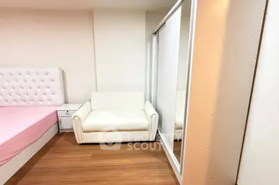 Cozy bedroom with white furniture and wooden flooring