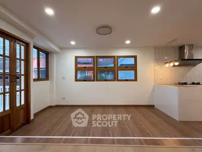 Spacious living room with wooden flooring and modern kitchen design