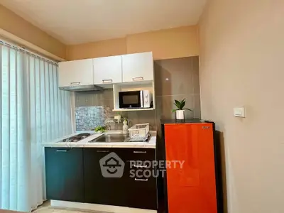 Modern compact kitchen with red fridge and sleek cabinetry