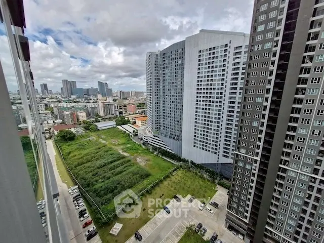 Stunning cityscape view from high-rise apartment with lush green surroundings and modern architecture.