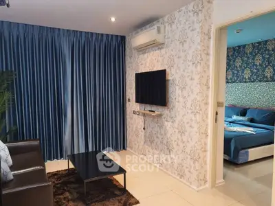 Stylish living room with elegant blue curtains and wall-mounted TV, leading to a cozy bedroom.