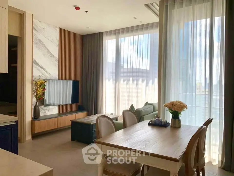 Elegant living room with natural light, modern decor, and stylish furniture in a high-rise apartment.