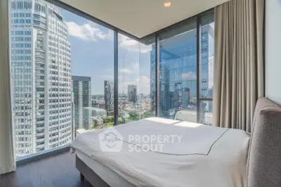 Luxurious bedroom with panoramic city views and floor-to-ceiling windows in modern high-rise apartment.