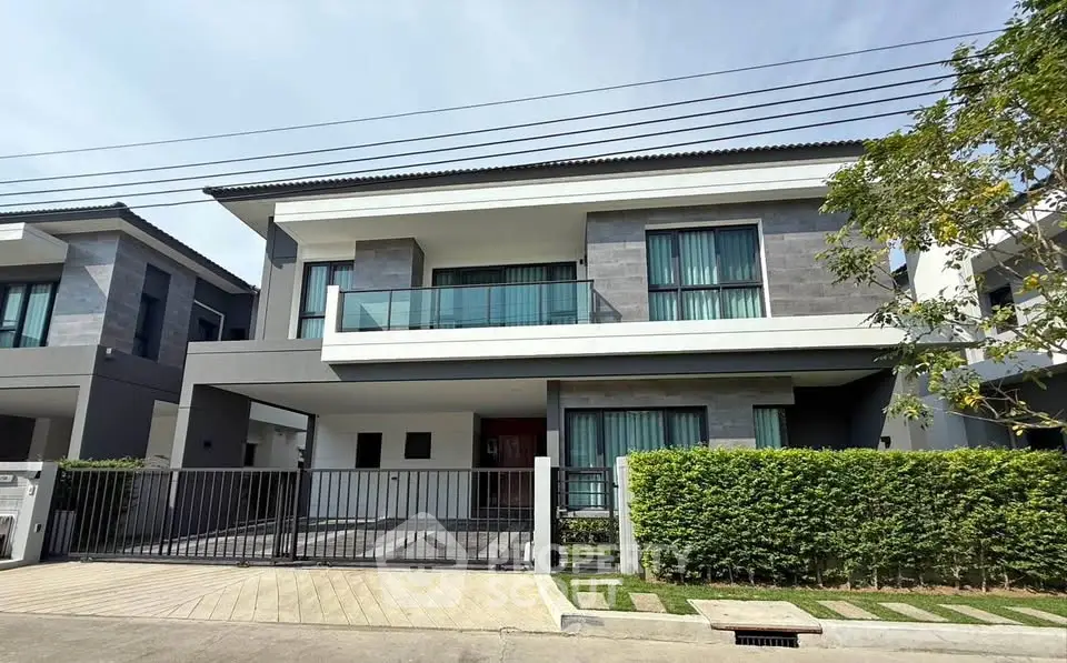 Modern two-story house with sleek design and spacious balcony in a serene neighborhood.