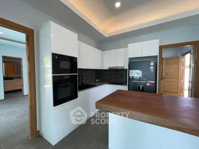 Modern kitchen with sleek appliances and wooden accents in a stylish home