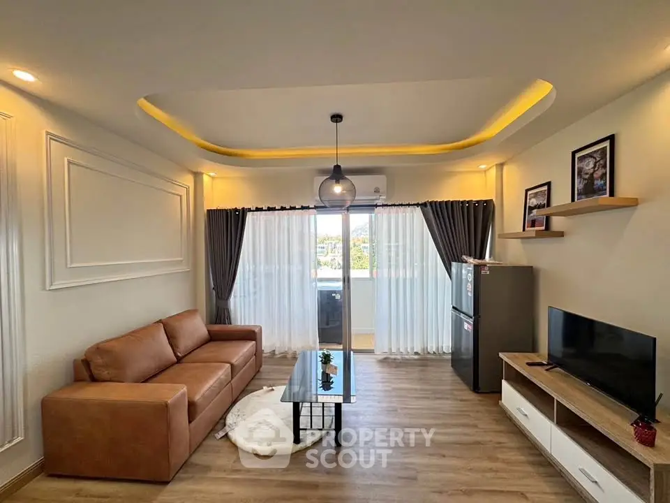 Modern living room with stylish decor, leather sofa, and natural light from large windows.
