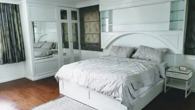Spacious bedroom with elegant decor and large windows for natural light