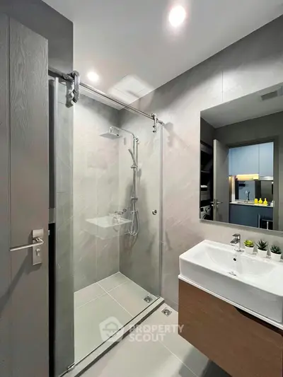 Modern bathroom with sleek shower and stylish vanity in contemporary apartment.