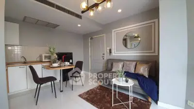 Modern living room with open kitchen, stylish decor, and cozy seating area.
