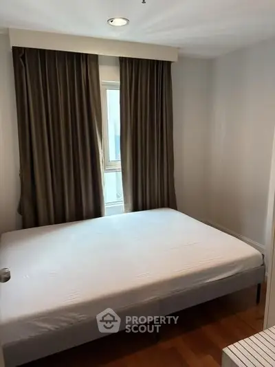Cozy bedroom with natural light and elegant curtains in modern apartment.
