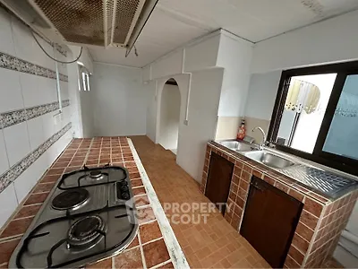 Charming kitchen with rustic tile countertops and gas stove, perfect for culinary enthusiasts.