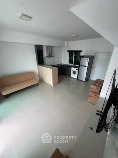 Modern open-plan living area with sleek kitchen and appliances