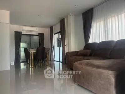 Spacious living room with elegant dining area and plush sofa, perfect for modern living.