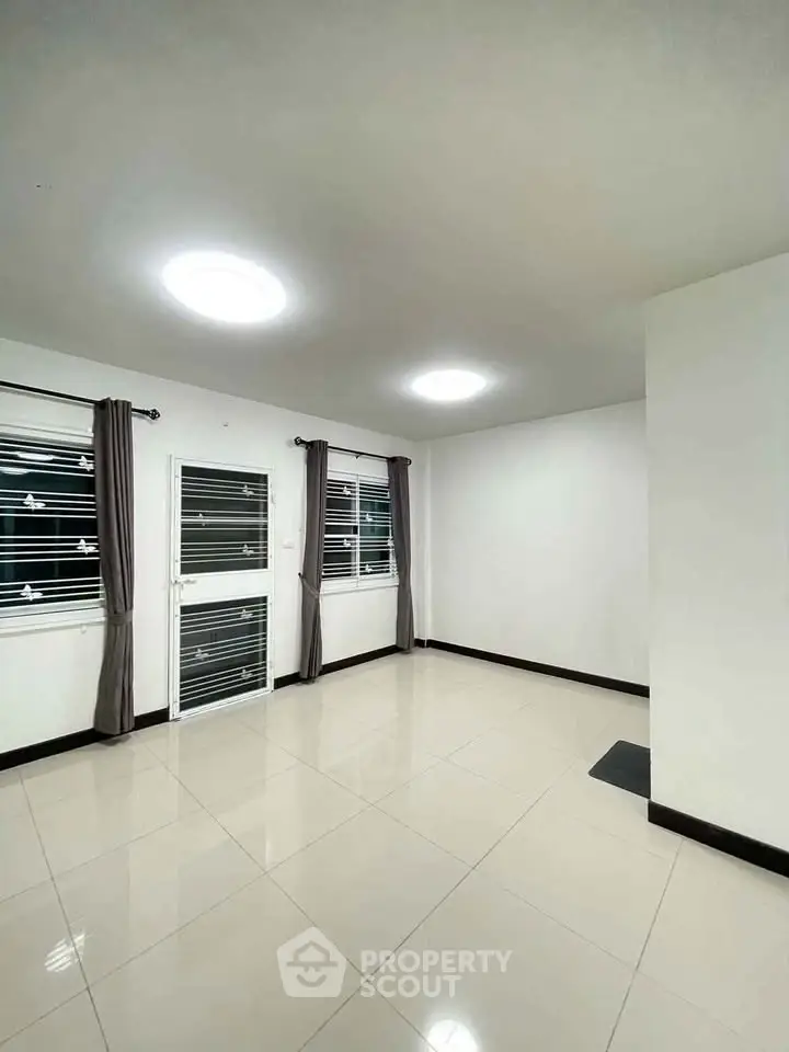 Spacious unfurnished room with large windows and modern lighting, perfect for customization.