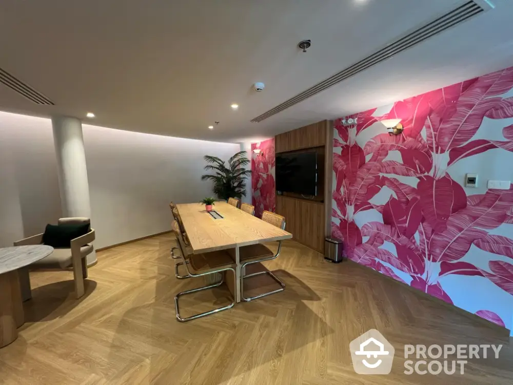 Stylish dining room with vibrant pink tropical wallpaper and modern wooden table