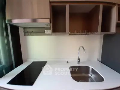 Modern kitchen with sleek countertop and built-in stove in a stylish apartment.